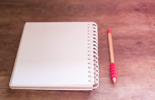 Work station with notebook and pencil with vintage filter, stock photo