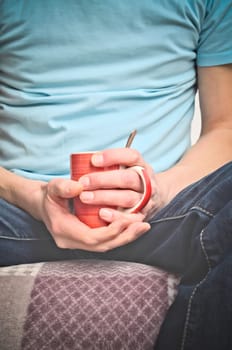 Young man with coffee pot on a couch