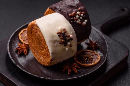 Round sweet New York roll croissant with chocolate cream filling on a dark concrete background