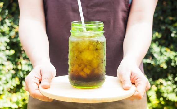Barista serving iced black coffee with vintage filter effect, stock photo