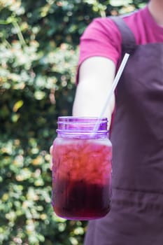 Barista serving iced black coffee, stock photo
