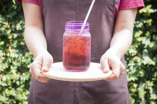 Barista serving iced black coffee, stock photo
