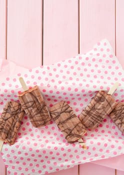 Homemade ice cream on the stem with chocolate on dots paper