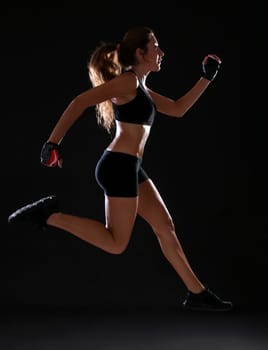 Fitness. Young woman doing exerciseover black background