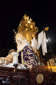 Pieta Holy Week float with moon getting close to the church, Spain