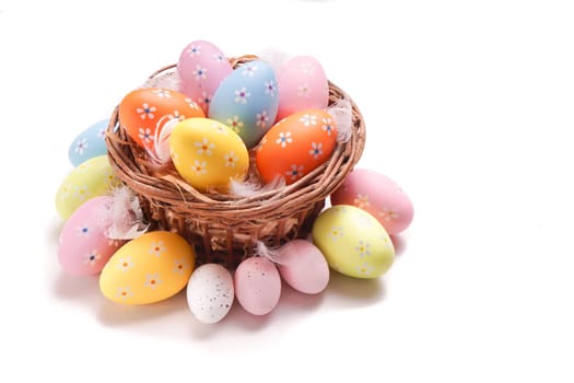 Colorful Easter eggs gathered in a basket, isolated on white