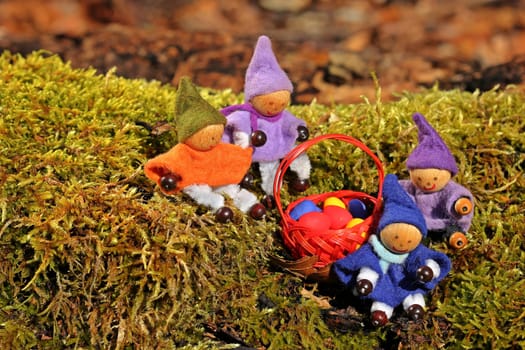 Four little gnomes are looking for Easter eggs in the forest