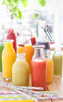 Various colorful smoothies in small bottles