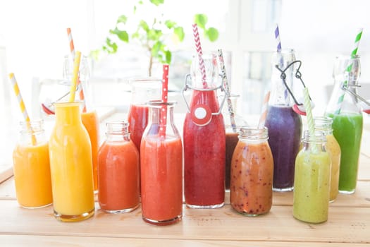 Various colorful smoothies in small bottles