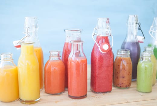 Various colorful smoothies in small bottles
