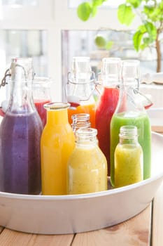 Various colorful smoothies in small bottles