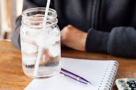 Woman's hand holding a cold glass of water, stock photo