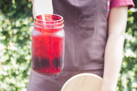 Barista serving iced black coffee, stock photo