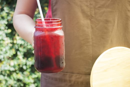 Barista serving iced black coffee with vintage filter effect, stock photo