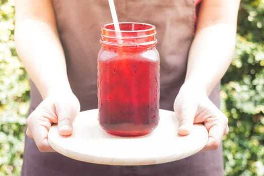 Barista serving iced black coffee with vintage filter effect, stock photo