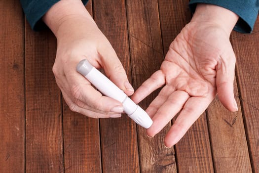 a lady&#39 s hands measuring blood glucose with a home test to control her diabetes