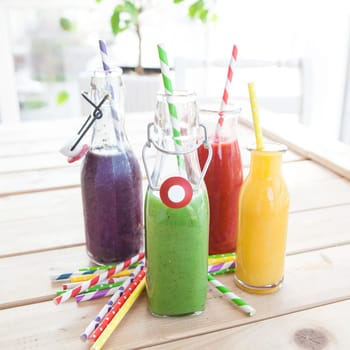 Various colorful smoothies in small bottles