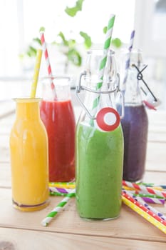 Various colorful smoothies in small bottles