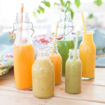 Various colorful smoothies in small bottles
