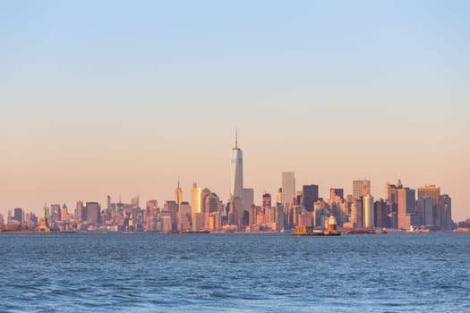New York City Manhattan downtown skyline at sunset with skyscrapers illuminated over Hudson River panorama. Square composition, copy space.