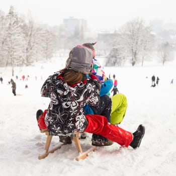 Children sledding and having fun on first winter snow.