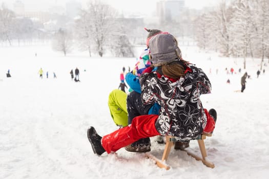 Children sledding and having fun on first winter snow.