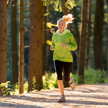 Pretty young girl runner in the forest.  Running woman. Female Runner Jogging during Outdoor Workout in a Nature. Beautiful fit Girl. Fitness model outdoors. Weight Loss. Healthy lifestyle.