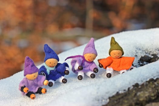Four little gnomes sit in the snow