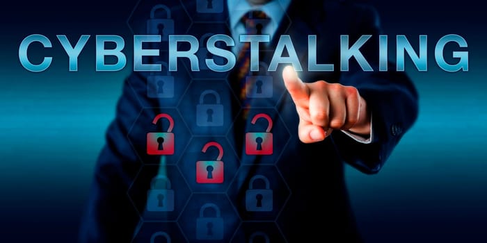 Forensic investigator is pushing CYBERSTALKING on a touch screen interface. Technology concept for the continuous process cyberbullying, monitoring, identity theft, threat and online vandalism.