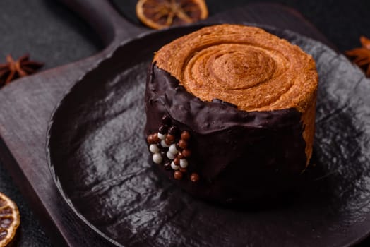 Round sweet New York roll croissant with chocolate cream filling on a dark concrete background