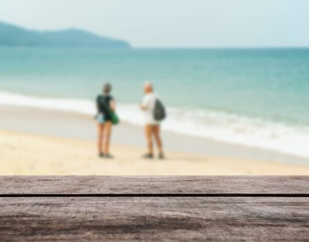 Wood table top on blurred blue sea and white sand beach with some people - Can be used for display or montage your products