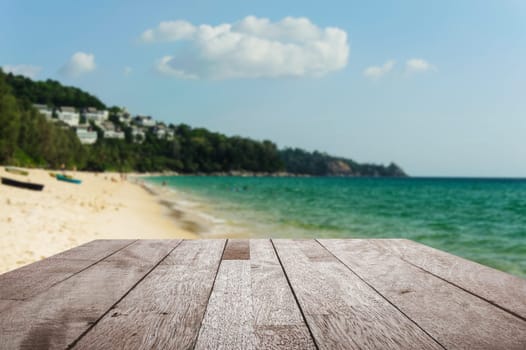 Wood floor top on blurred blue sea and white sand beach with some people - Can be used for display or montage your products