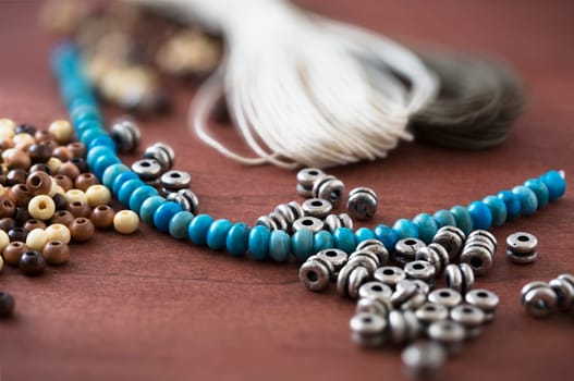 Collection of metal, wooden and turquoise beads with cord for jewelry making.