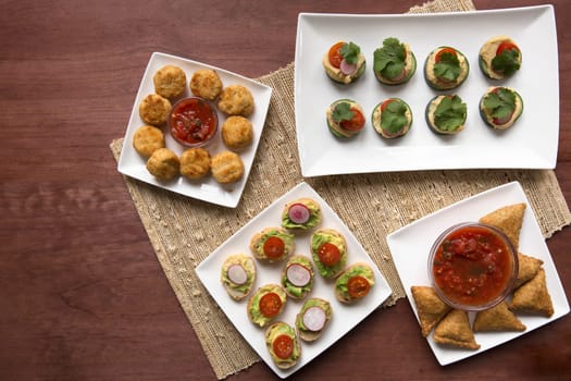 A variety of healthy tapas including avocado toast, samosas and cucumber hummus bites.