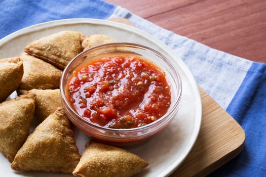 Vegetables samosas with tomato dipping sauce.