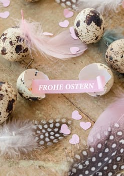 Quail eggs and colorful feathers at Easter on rustic background