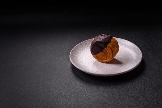 Round sweet New York roll croissant with chocolate cream filling on a dark concrete background