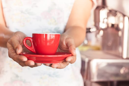 Woman's hand holding red coffee cup, stock photo