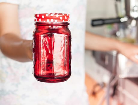 Woman's hand holding red glass, stock photo