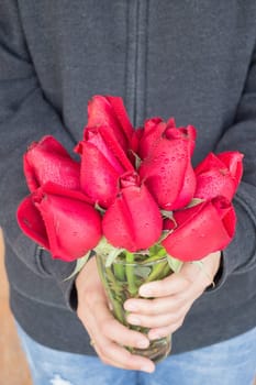 Hand hold glass of red rose, stock photo