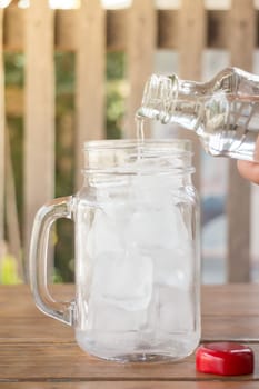 Drinking water is poured into iced glass, stock photo