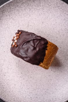 Round sweet New York roll croissant with chocolate cream filling on a dark concrete background