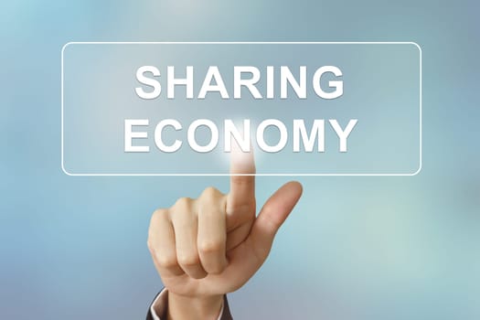 business hand pushing sharing economy button on blurred background