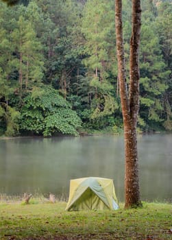 Green camping tent with fog over lake in the morning at Pang Oung national park in Mae Hong Son, Thailand