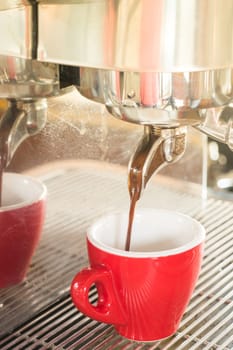 Fresh brewing hot coffee from espresso machine with vintage filter effect, stock photo