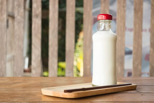 Bottle of milk on wooden table, stock photo