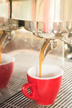 Fresh brewing hot coffee from espresso machine with vintage filter effect, stock photo