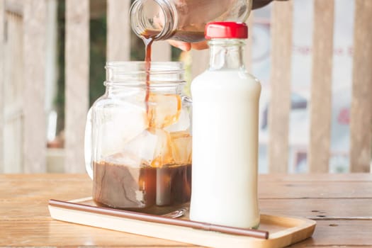 Pouring espresso to iced glass of coffee, stock photo