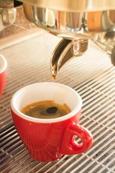 Fresh brew hot coffee from espresso machine with vintage filter effect, stock photo