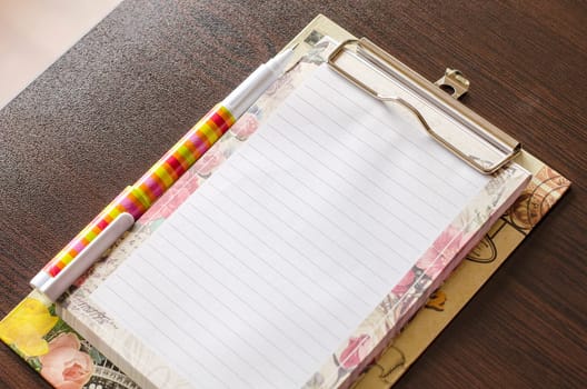 Notebook and pen on wood table